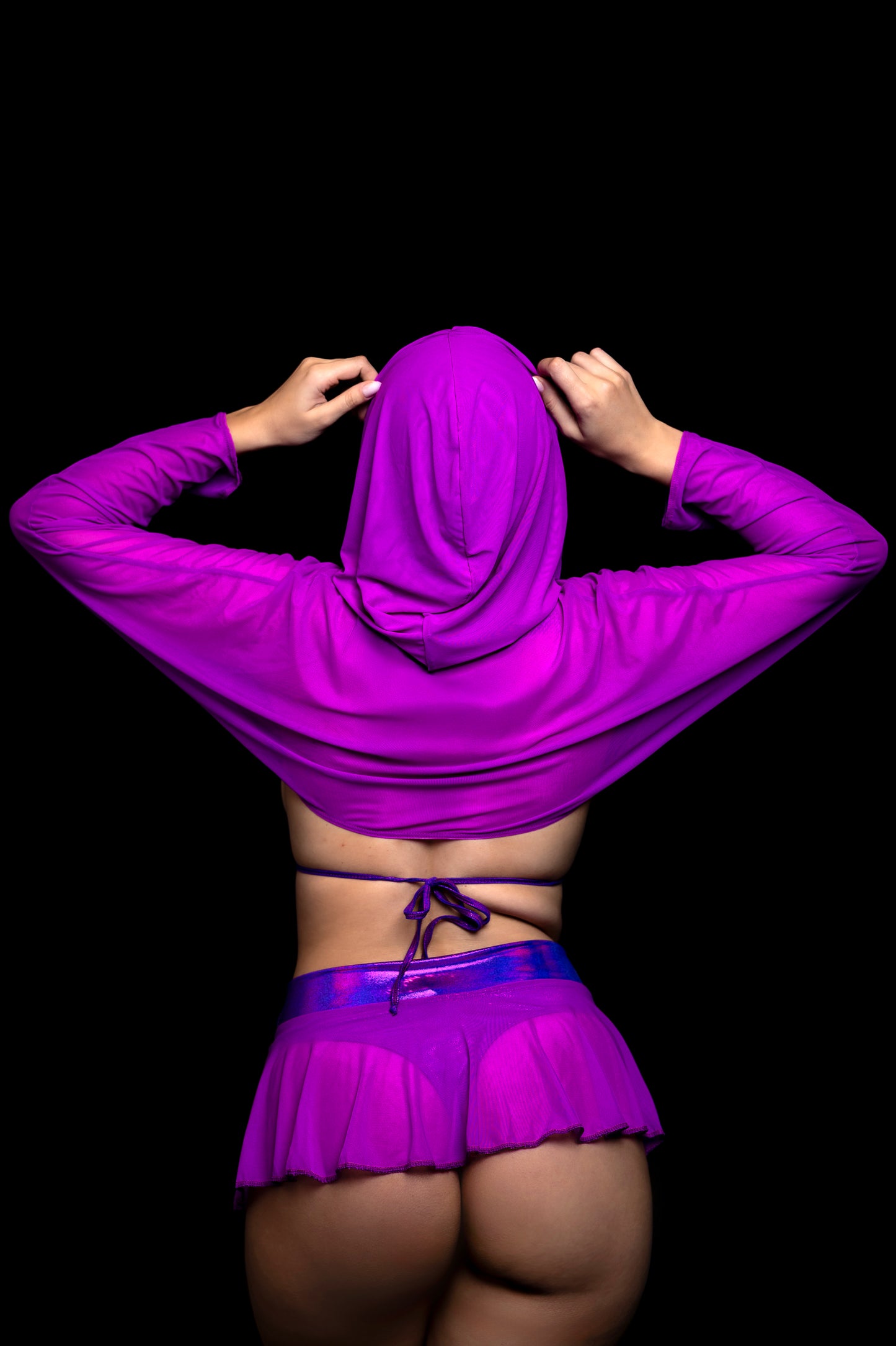 Model wearing Brigitewear International's Grape Babe Hooded Mesh Shrug stylish cover-up, back to camera, against a black background.