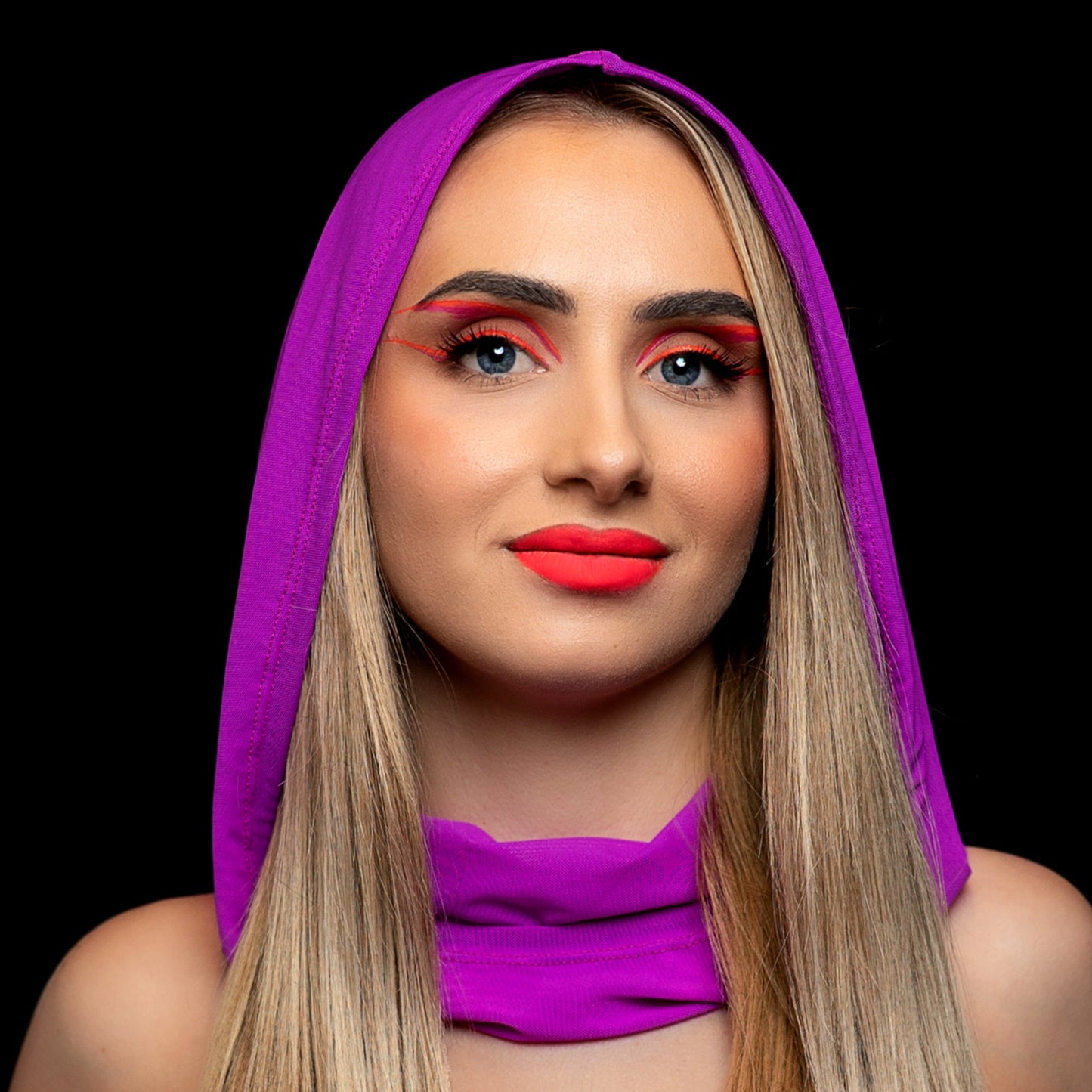 A woman with long blonde hair and bold red makeup poses against a black background, wearing the Brigitewear International, LLC Grape Babe Mesh Hood.