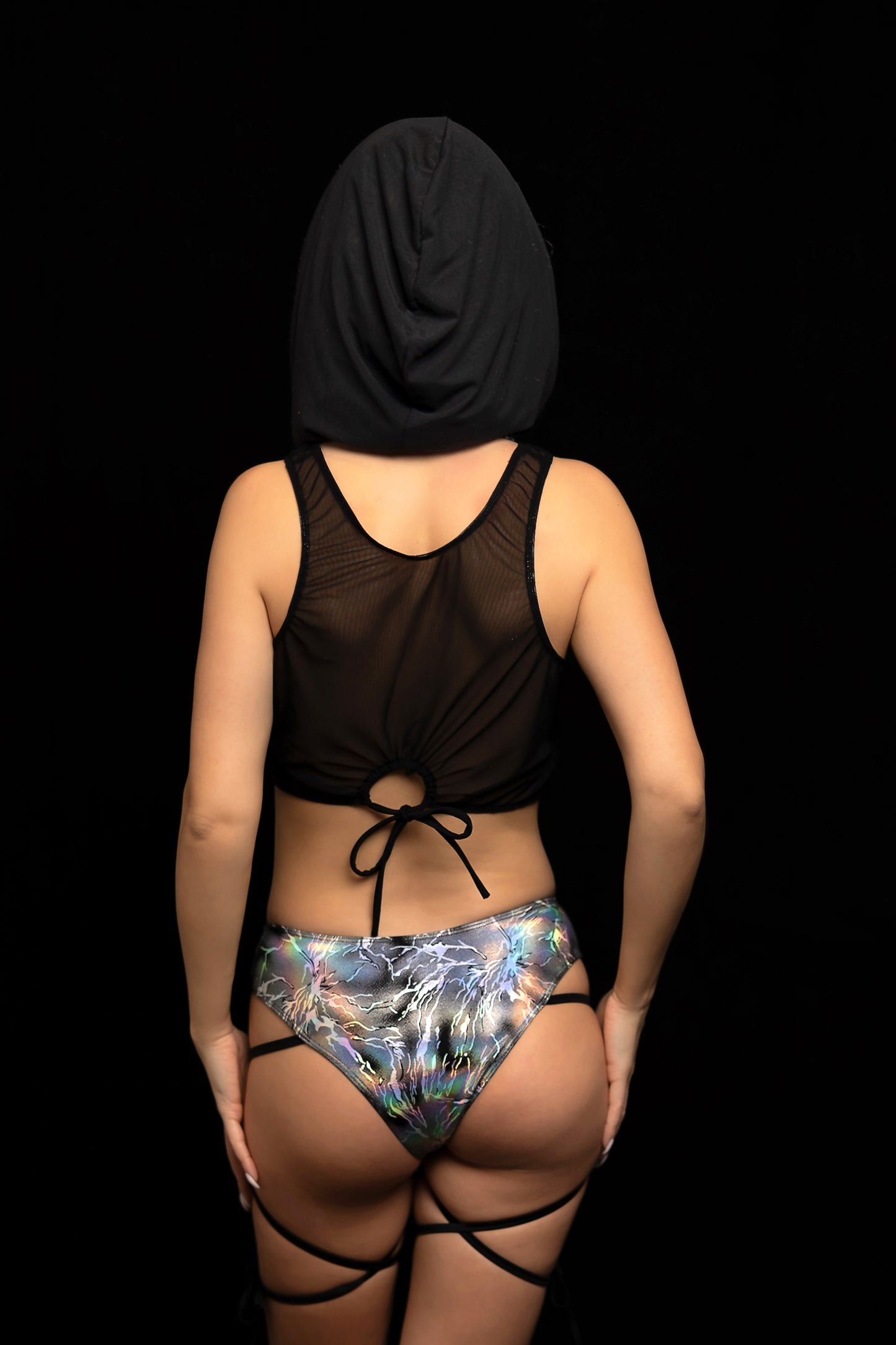 A person models Brigitewear International, LLC's Electric Glint Rave Swimwear & Festival Bikinis, standing with their back to the camera against a black background.