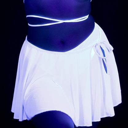 Wearing the Brigitewear International Dreamy Circle Skirt, lit by ultraviolet light, against a dark background.