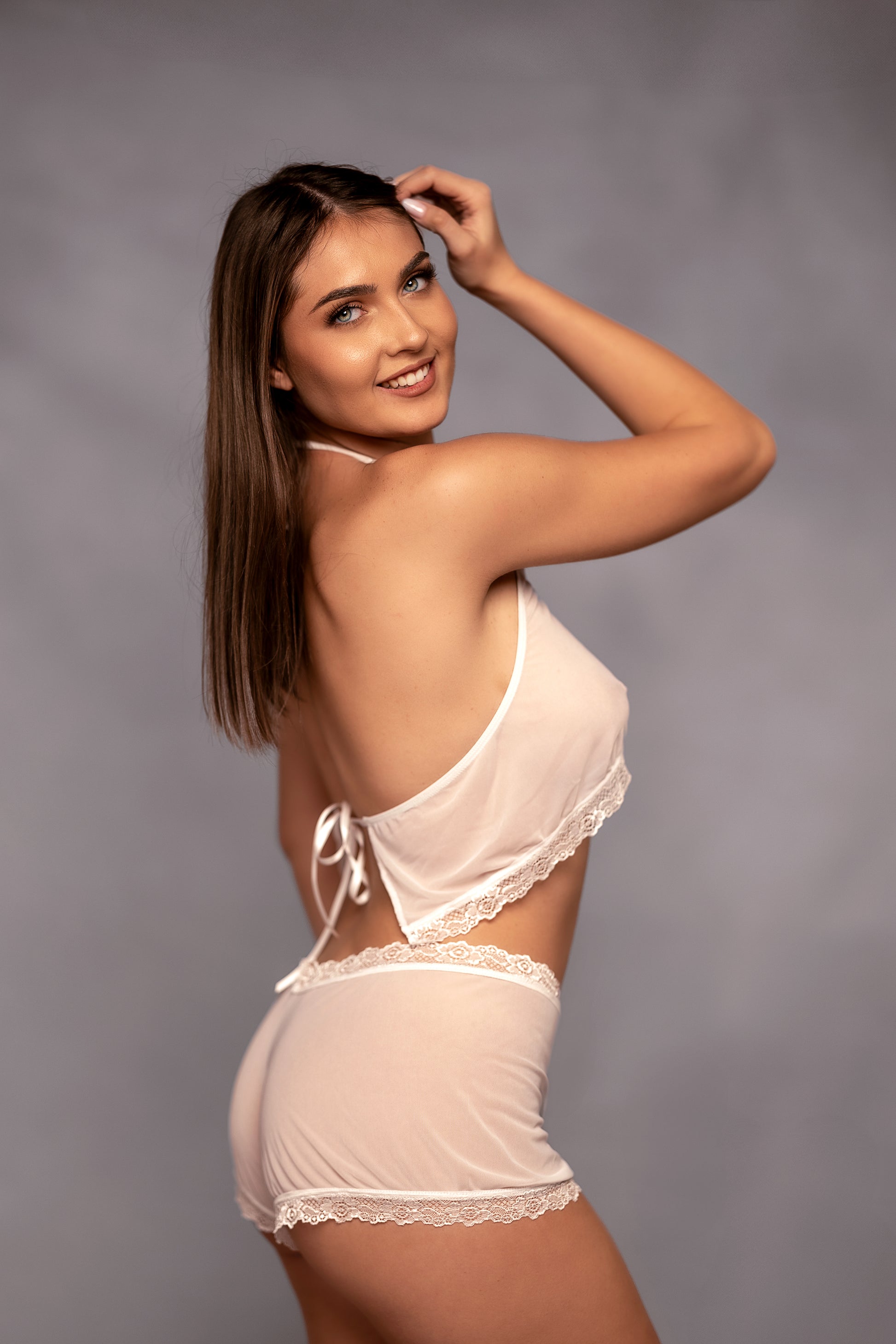 A woman wearing Brigitewear International, LLC's Malibu Nights Boy Shorts in white.