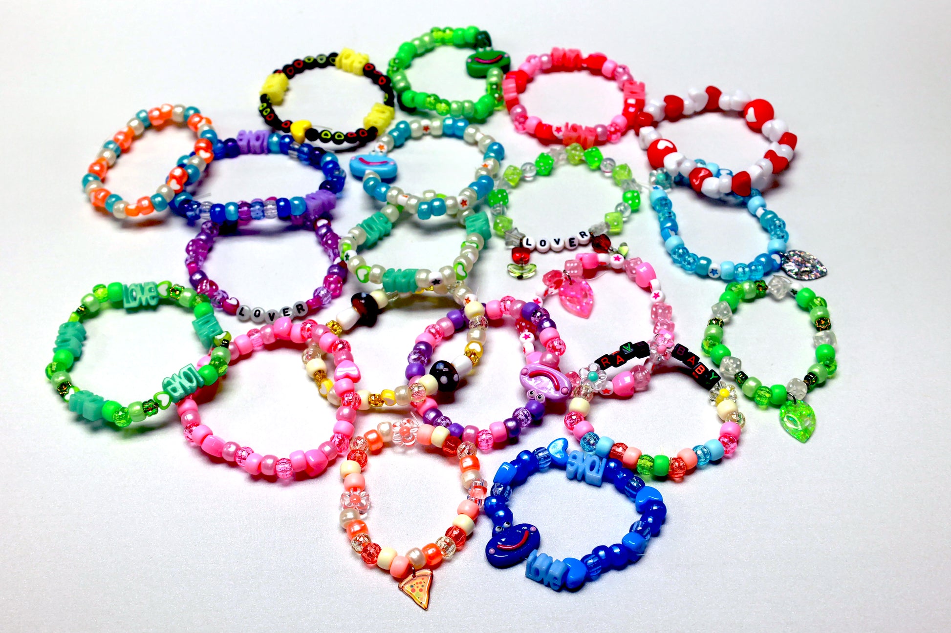 Baby's 1st Kandi by Brigitewear International, LLC features colorful beaded friendship bracelets with charms and letter beads, beautifully arranged on a white background.