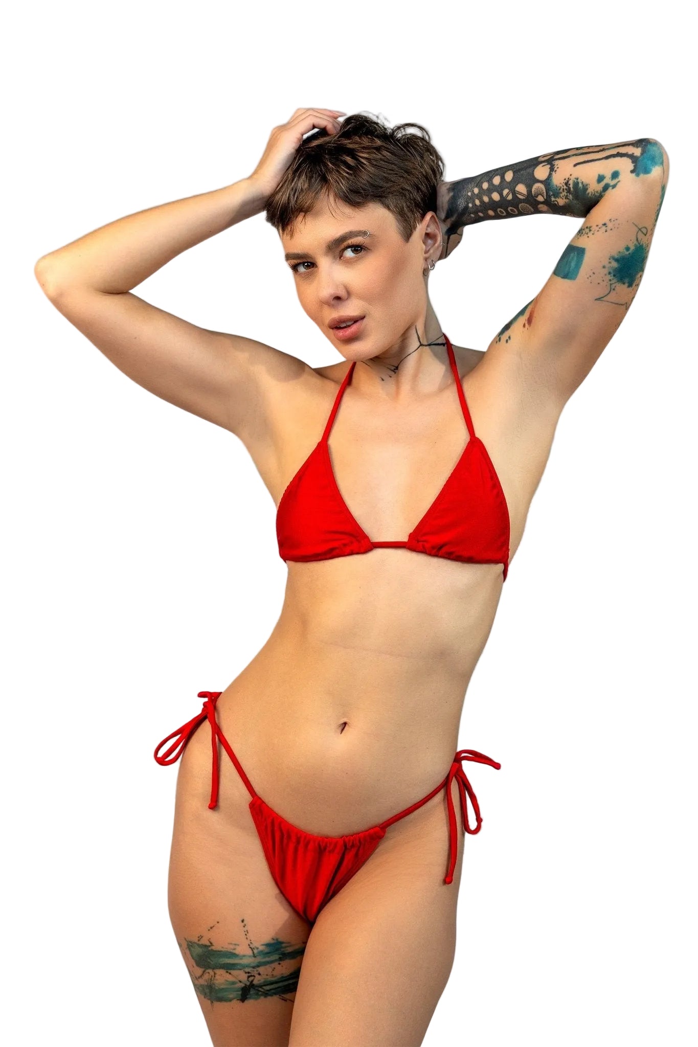 A person models the Brigitewear International, LLC Cannes Bikini Top on a sandy beach with the ocean and blue sky in the background.