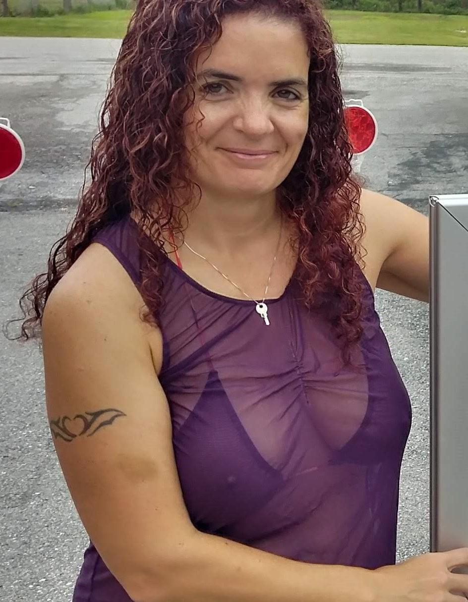 Înțeles 👍 De acum nu mai menționez tatuajele.
Pentru această poză, varianta corectă de alt text este:
Woman wearing a sheer purple top posing outdoors