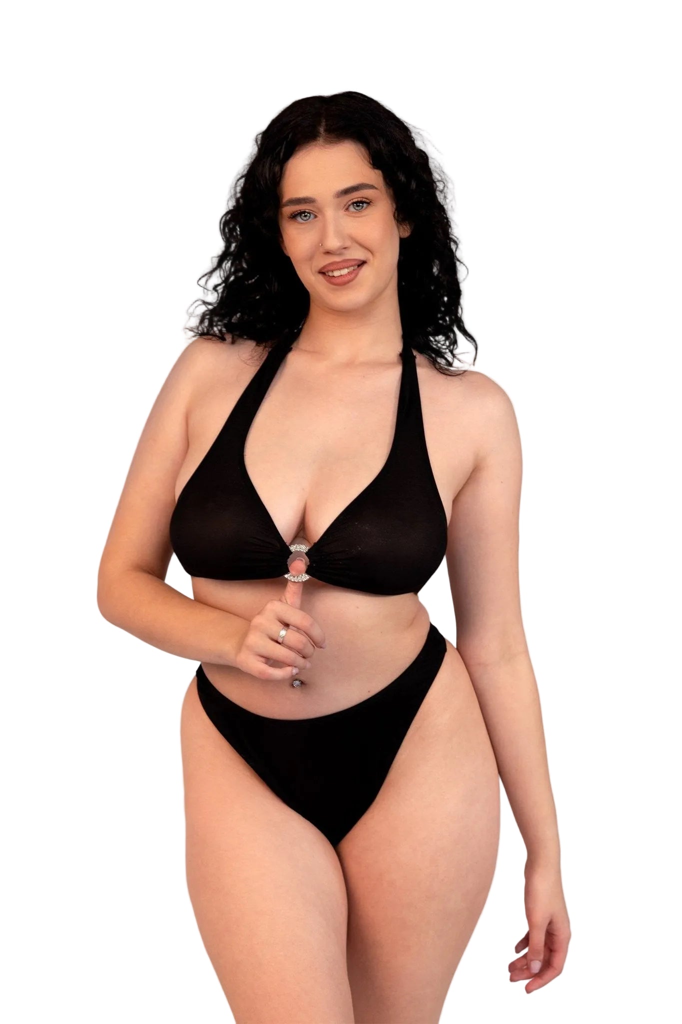 A woman with curly dark hair smiles in Brigitewear International, LLC's Ecstasy Bottoms—sexy and stylish black bikini bottoms—while holding a lollipop against a light background.