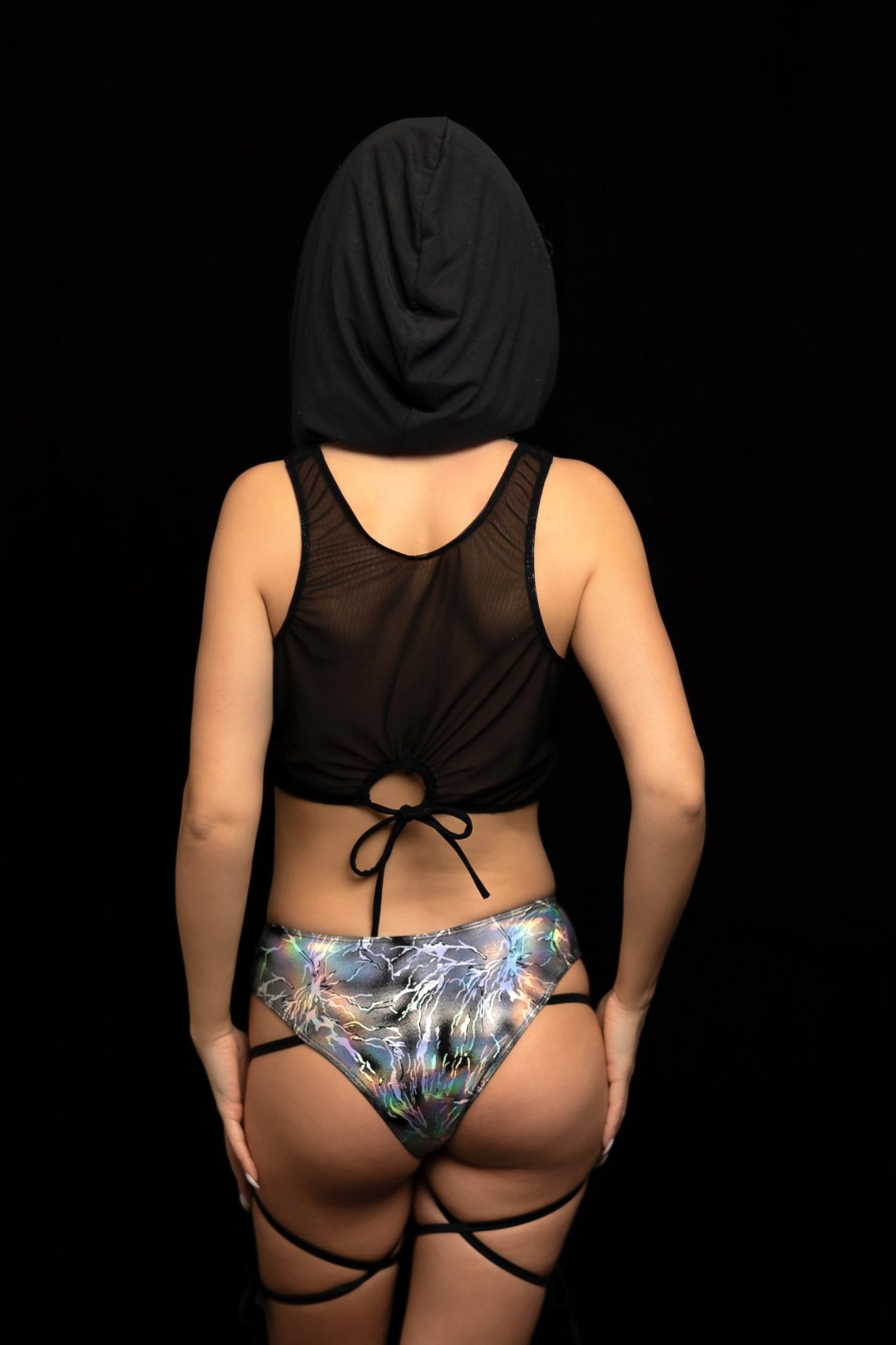 A person models Brigitewear International, LLC's Electric Glint Rave Swimwear & Festival Bikinis, standing with their back to the camera against a black background.