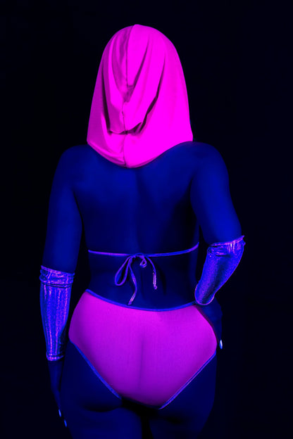 Person wearing a Brigitewear International Grape Babe Mesh Hood - Rave Festival, in pink with gloves under blacklight, glowing neon from the back.