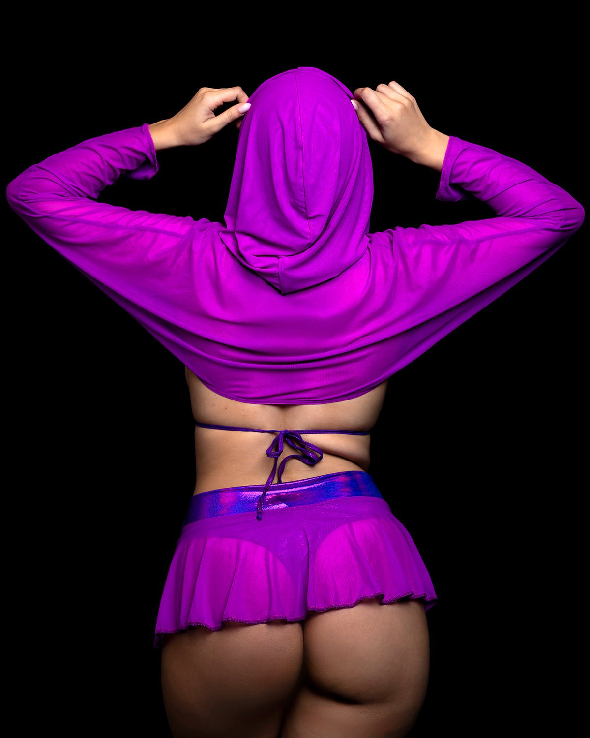 A person from behind wearing a purple Grape Babe Mesh Hooded Shrug- Rave Festival and matching mini skirt.