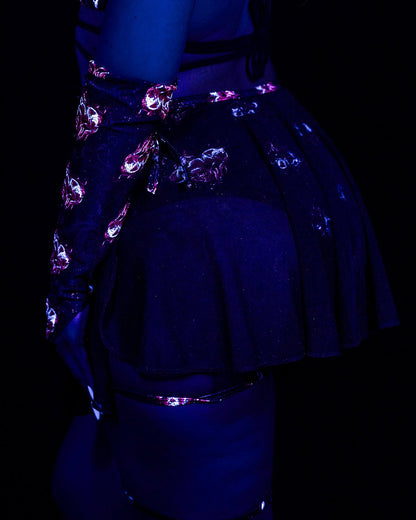 A person wearing a dark skirt and Inferno Heart Pointed Gloves-Rave Festival with a glowing pink heart pattern.