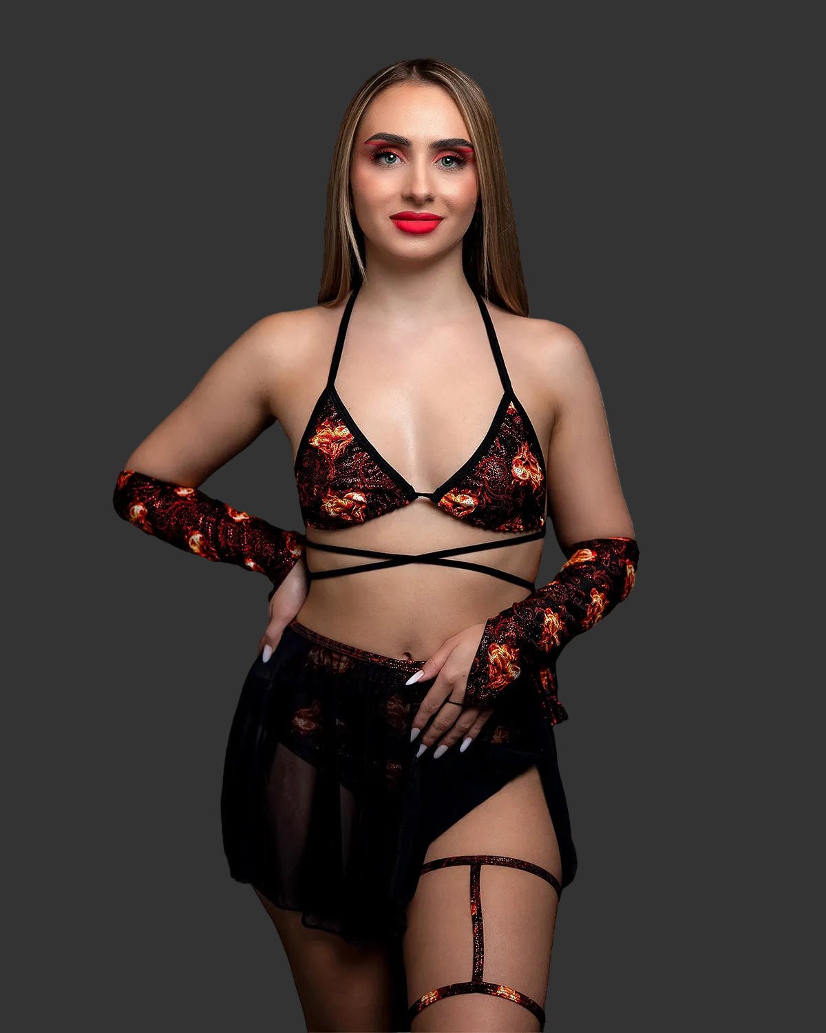 Woman wearing an Inferno Heart Triangle Top-Rave Festival flame-patterned bikini, arm sleeves, and a black sarong.