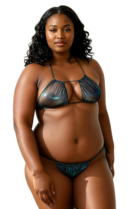 A woman stands and smiles at the camera, wearing the Jade Sparkle Bikini Top by Brigitewear International, LLC—a shiny, dark, halter-style bikini.