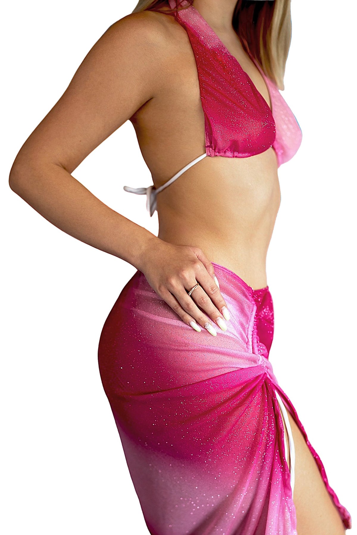 A woman poses with her hand on her hip against a white background, wearing the Pink Sparkle Ombre Scrunchie Skirt by Brigitewear International, LLC paired with a matching pink bikini top.