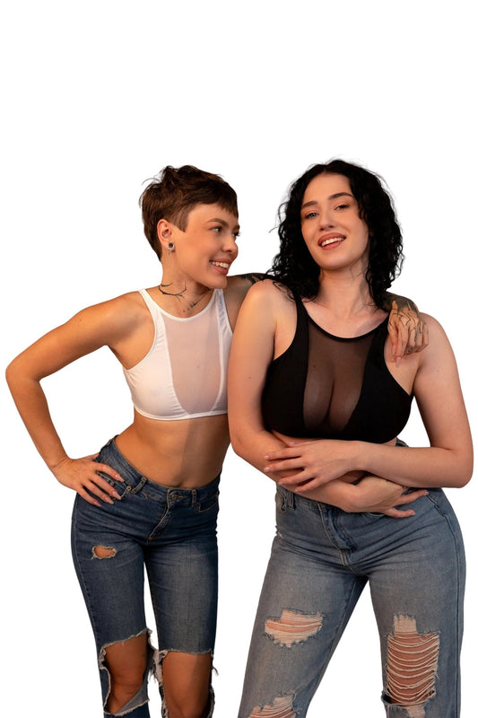 Two women in Brigitewear International's Sporty Knock Out Top pose together, smiling in sheer crop tops and ripped jeans against a white background.