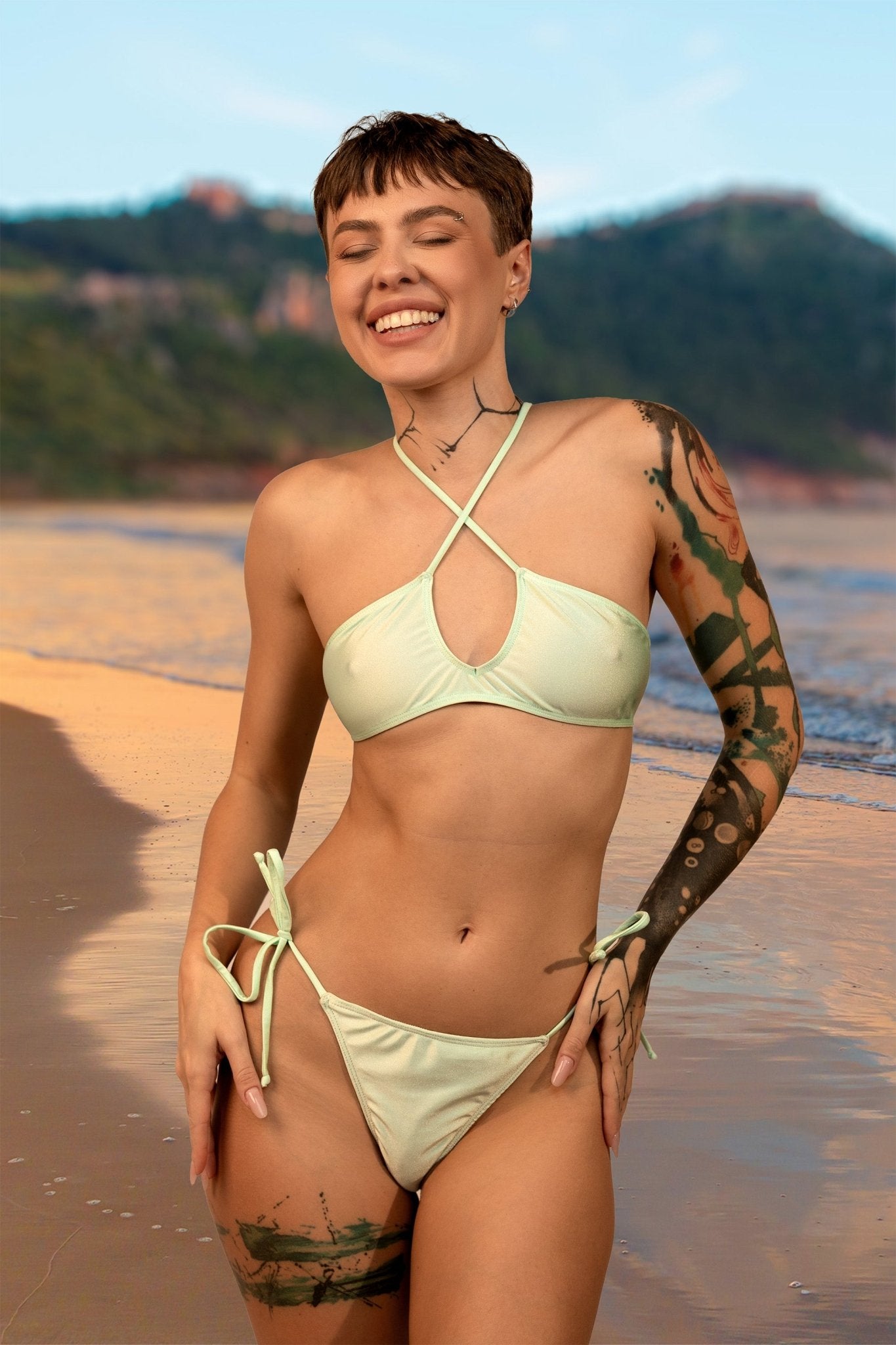 A smiling person wears the Teardrop Bikini Top by Brigitewear International