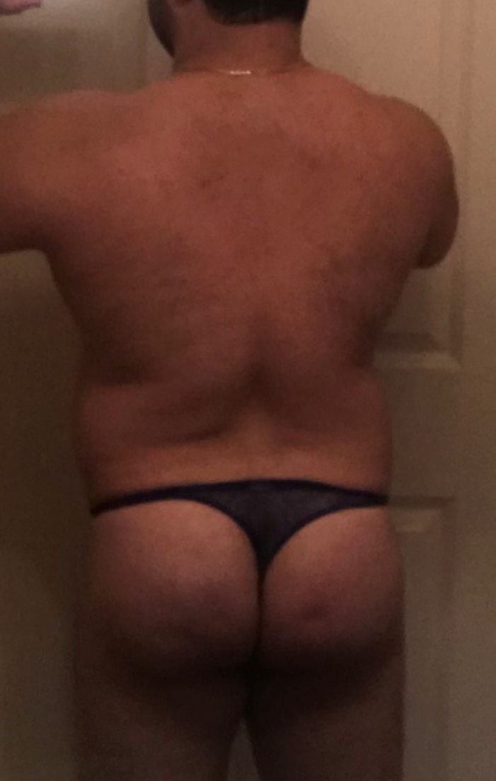 A person standing with their back to the camera, wearing dark Brigitewear bikini bottoms.